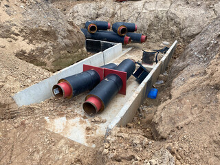 Large industrial modern new large diameter polyethylene plastic water pipes lie in a pit...