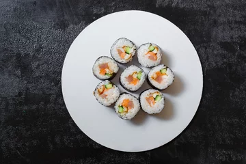 Tuinposter sushi rolls with salmon on a plate © Yana