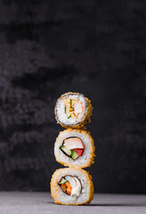 hot sushi rolls on a black background close up