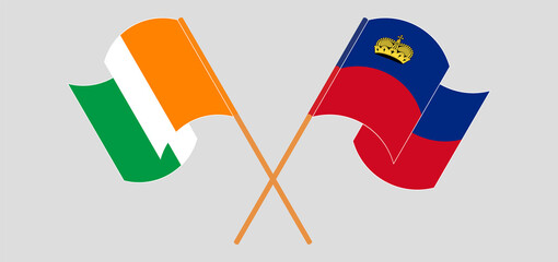 Crossed and waving flags of Republic of Ivory Coast and Liechtenstein