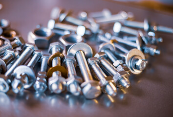 Metal chrome bolts and nuts in a chaotic order industrial background