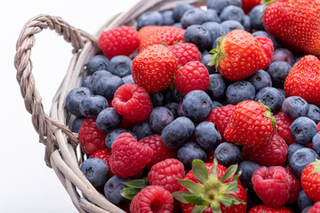 Raspberry, strawberry and blueberry berries in a basket