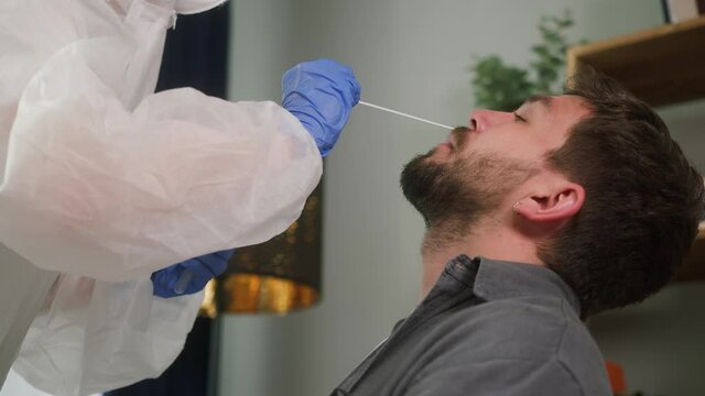 PCR test process, Doctor medical staff worker wearing protective equipment takes sample from nose of a patient to antigen test for coronavirus, laboratory in airport terminal for tourists, protection