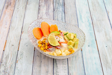 glass bowl with serving of Peruvian fish ceviche with avocado, corn, lime and sweet potato
