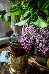hot tea and a bouquet of lilacs