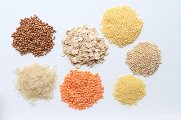 Top view of cereals of different types on white background.Buckwheat,oatmeal,rice,lentils,couscous,millet and quinoa