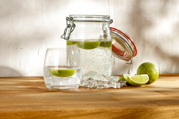 A cold fresh drink on a summer day on a wooden table in the shade of the interior and the shadows of trees on a rustic textured wall 