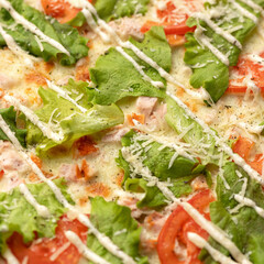Hot pizza background or texture. Close-up shot of Melted cheese on pizza with lettuce and tomatoes. Vegan or vegetarian food. Soft focus.