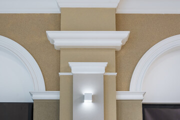 Detail of corner ceiling with intricate crown molding on column with spot light