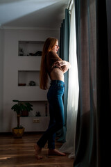 girl undresses near the window
