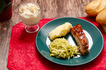 Roasted ribs marinated with barbecue sauce served with mashed potatoes, spaghetti and bread. Plate of food served on wooden table