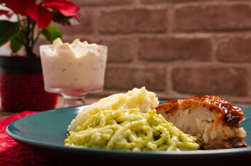 Roasted ribs marinated with barbecue sauce served with mashed potatoes, spaghetti and bread. Plate of food served on wooden table