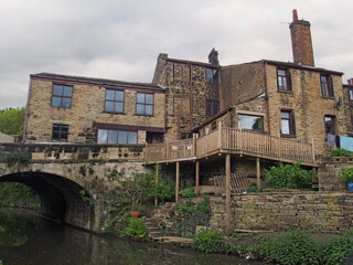 a row of old houses next to a bridge crossing the rochdale canal in mytholmroyd west yorkshire
