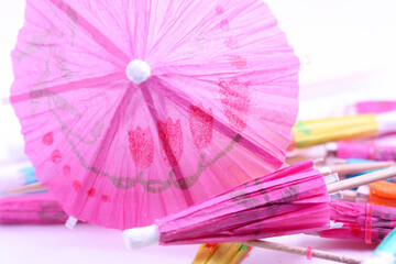Umbrella for cocktail of pink color a close up. A background with the opened paper umbrella horizontally.