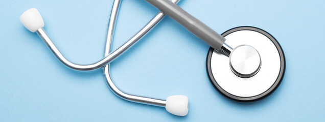 Grey stethoscope on blue background. Medical concept