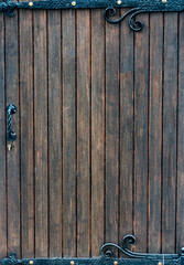 Vintage old wooden door with metal inserts. Vertical shot.