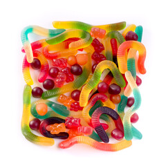 Pattern of colorful gummy bears and worms against white background top view.