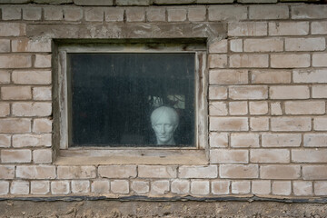 the facade of the white brick building of the Soviet Union with a window where a plaster cast of plaster can be seen inside