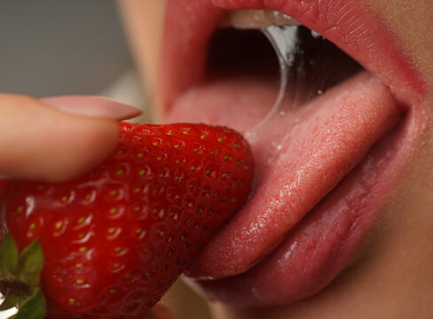 Sexy womans lips. Erotic concept. Sexy lips with strawberries. Oral sex. Erotic woman secret and sex symbols concept. Orgasm. Talk sex. Strawberry lubricant.