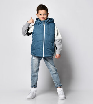 teenage boy in a blue down jacket, a sleeveless zip-up jacket and jeans with white sneakers. on white background