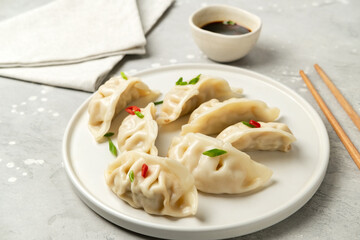 Jiaozi gyoza dumplings steamed on white plates with soy sauce and chili sauce. Food takeaway, home delivery