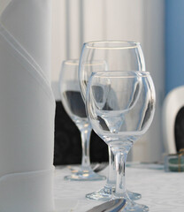 Three bluish  empty glasses and a napkin on a table in a fine restaurant