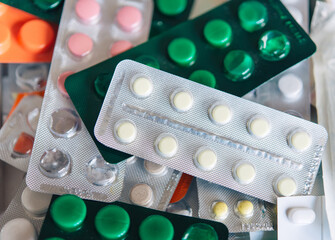 bunch of medical pills in white, pink, green and other colors. Tablets in plastic packaging. Health...