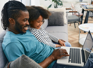 Obraz premium Father's day. Dad and daughter look at the laptop together and laugh. Fatherhood, happy family