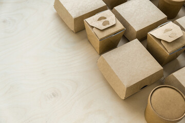 Closeup of kraft paper or cardboard packages on wooden background with space for your copy
