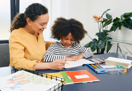 Mom Helps Her Daughter Doing School Homework At Home. Happy Mother And Schoolgirl, Happy Family