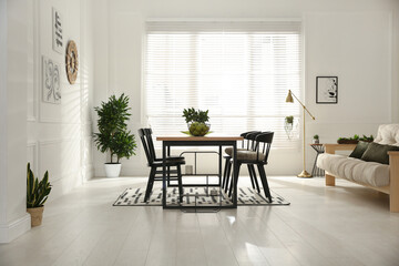 Stylish wooden dining table and chairs in room. Interior design