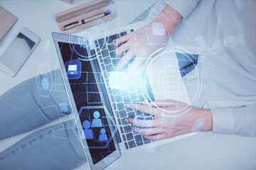 Double exposure of woman hands working on computer and social network theme hologram drawing. Top View. People connection concept.