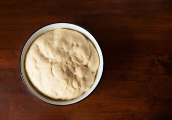 Process of raising the dough in a special basket. Dough made from natural sourdough. Wheat dough. Fermentation. Top view.