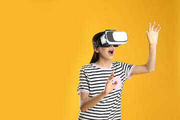 Woman using virtual reality headset on yellow background