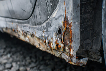 Heavy corrosion or rust appearing on the sides and bottom of the car. 