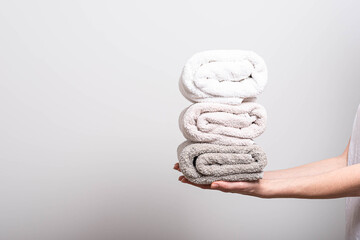 The woman is holding clean, folded towels. Terry towels. Order in the house