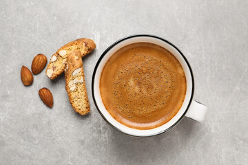 Tasty cantucci and cup of aromatic coffee on light grey table, flat lay. Traditional Italian almond biscuits