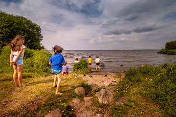 Lough Neagh in Northern Ireland summer 2021 children running into the water - obrazy, fototapety, plakaty