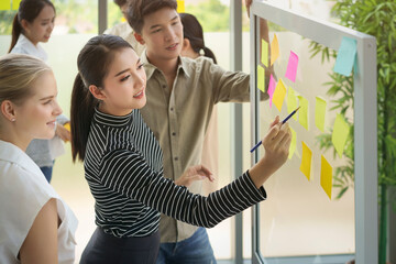 Business people meeting at office and use post it notes to share idea together. Post it note on...