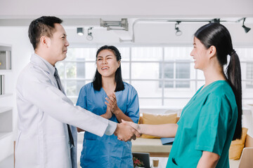 The team of medical personnel shakes hands with joy and smiles and happy expressions, the concept of success in health work young adult surgeon coworker nurse colleague cooperation