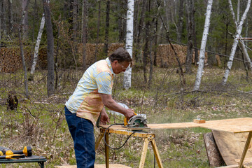 man with circular saw cutting board