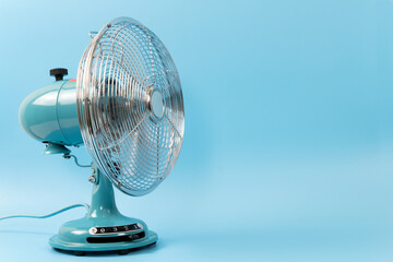 Vintage tabletop fan isolated on a blue background