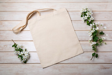 Rustic tote bag mockup with blooming apple tree branch in white vase