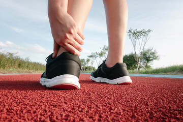 Female Athlete Runner Ankle Injury While Jogging in Running Track, Sport Woman Having Pain Her Ankles During Exercise Running. Sporty Woman Injured Muscle From Workout, Lifestyle and Heath Care