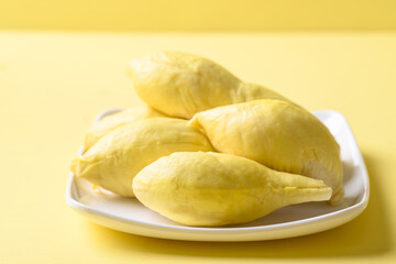 Ripe Thai durian fruit (Monthong) on plate with yellow background, Tropical fruit
