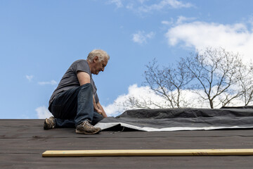 roofer putting down tar paper on roof
