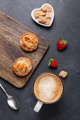 Coffee and tasty cakes on dark stone background. Coffee break concept. Top view