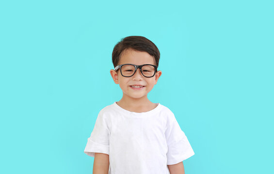 Portrait of smiling asian little boy child wearing glasses isolated over cyan background