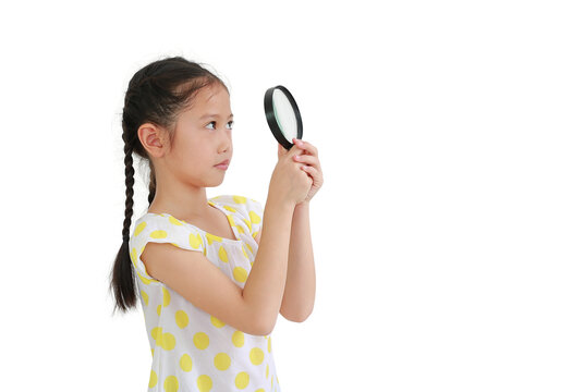 Asian little child girl looking up through a magnifying glass isolated on white background