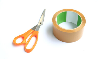 Coil adhesive tape and scissors isolated over white background. Universal packaging equipment. Selective focus